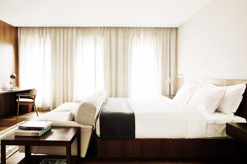 A guest room at Square Nine Hotel with a wraparound sofa and desk, Belgrade