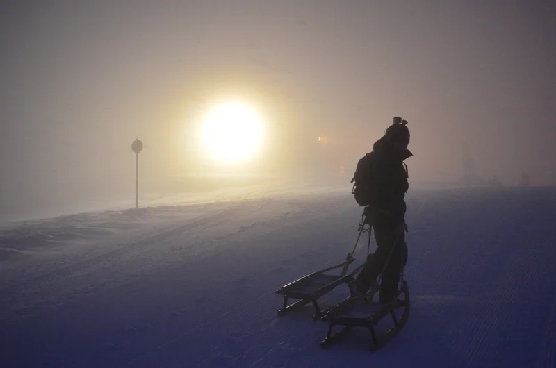 Emberek egy csoportja éjszakai szánkópályán St Antonban