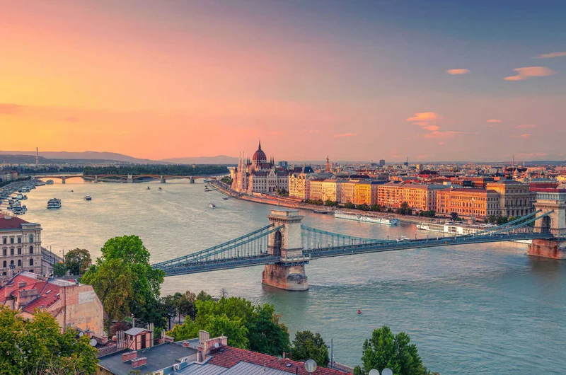 Budapest panorámás légi városképe a Széchenyi Lánchíddal és az Országházzal a nyári naplementében