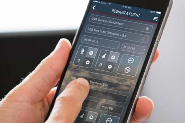 Person, die die LunaJets-App auf einem Smartphone nutzt, um einen Privatflug anzufordern.