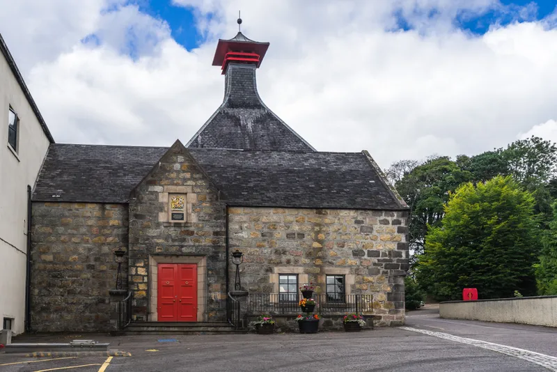 historic building with red door of the distillery in scotland