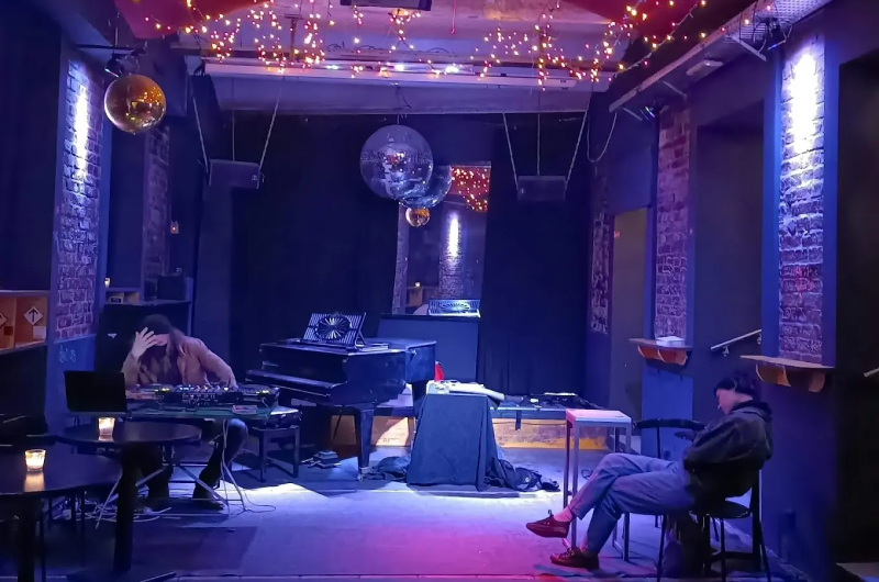 DJ fellép a meghitt bécsi Celeste klubban, fényfüzérekkel és kis tömeggel