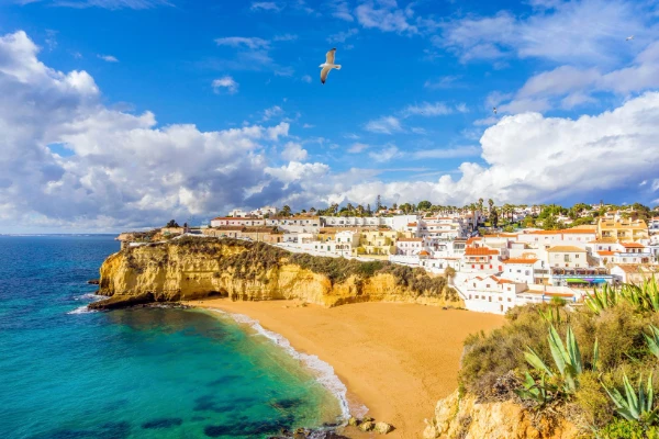 Panoramic view of Carvoeiro beach, with its yellow cliffs, clear turquoise water, and coastal village