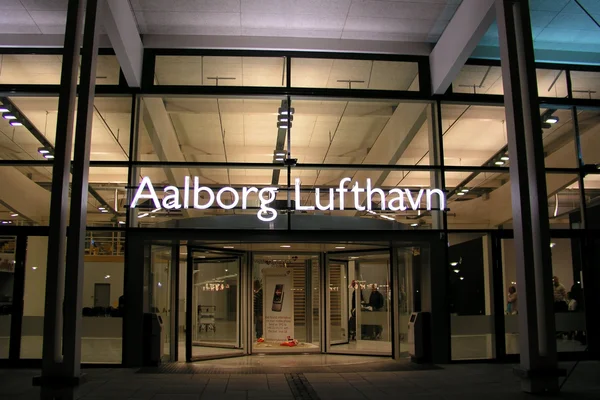 L'entrée du terminal de l'aéroport d'Aalborg la nuit avec portes illuminées.