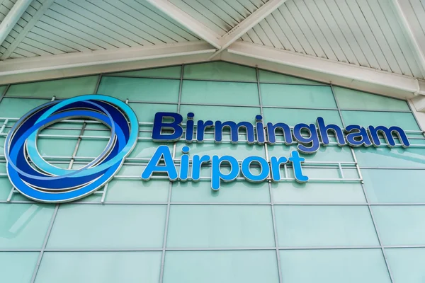 Letrero azul de neón «Aeropuerto de Birmingham» en fachada de vidrio y metal.