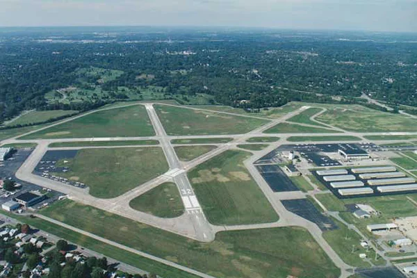 Vue aérienne de l'aéroport Bowman Field avec pistes et champs verts.