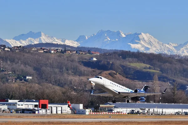 Aeronave comercial despega del Aeropuerto de Chambéry con Alpes nevados de fondo.