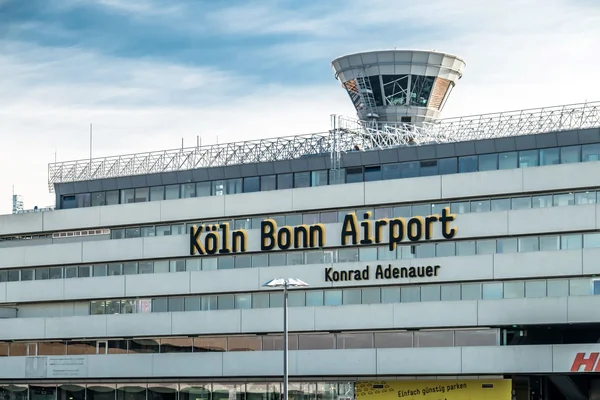 Terminal del Aeropuerto de Colonia Bonn con torre de control bajo cielo nublado.