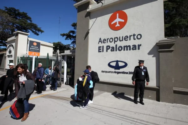 Passeggeri all'ingresso di Aeropuerto El Palomar con grande insegna bianca.