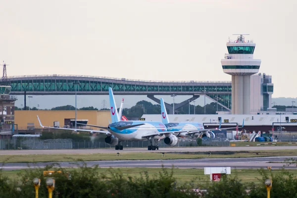 Avión comercial azul y blanco rodando en la pista del Aeropuerto de Londres Gatwick.