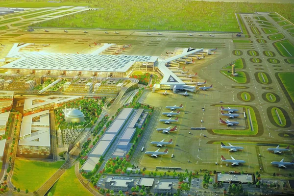 Luftaufnahme des Istanbul Airport mit Terminalgebäude, Flugzeugen und grüner Landschaft.