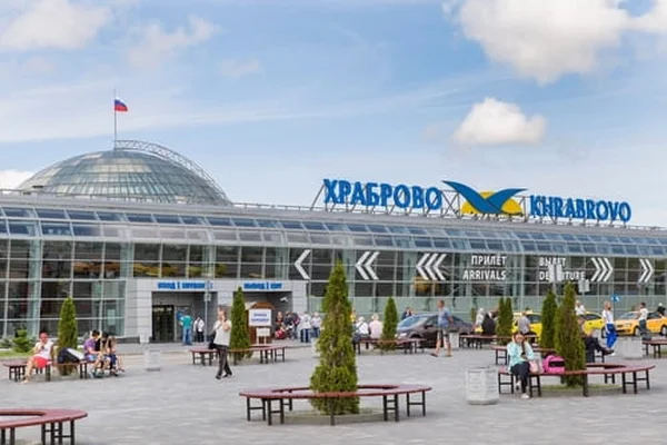 Terminal de l'aéroport de Khrabrovo avec dôme en verre et drapeau russe visible.