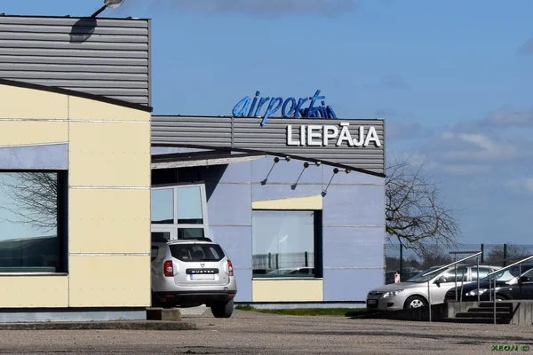 Terminal de l'aéroport Liepāja International avec architecture moderne et véhicules.