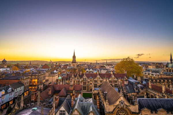 Vista aérea al atardecer del horizonte de Oxford con edificios históricos e iluminación dorada.