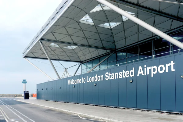 Señal de bienvenida del Aeropuerto de Londres Stansted con dosel arquitectónico moderno.