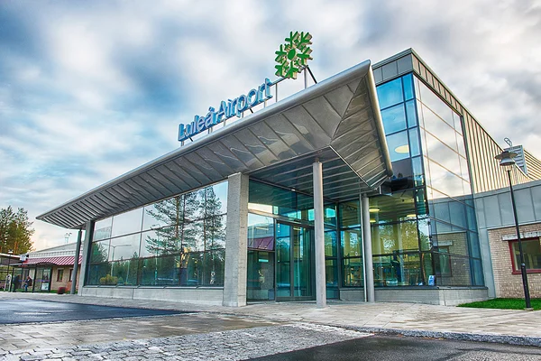 Terminal moderne de l'aéroport Luleå avec façades vitrées et auvent acier.