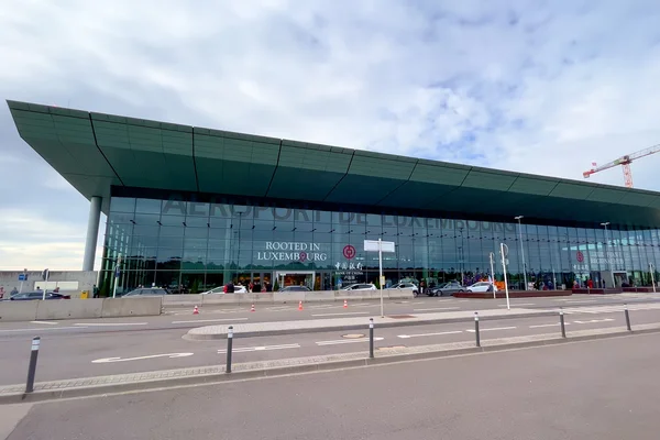 Terminal moderna con techo verde del Aeropuerto de Luxemburgo bajo cielo nublado.