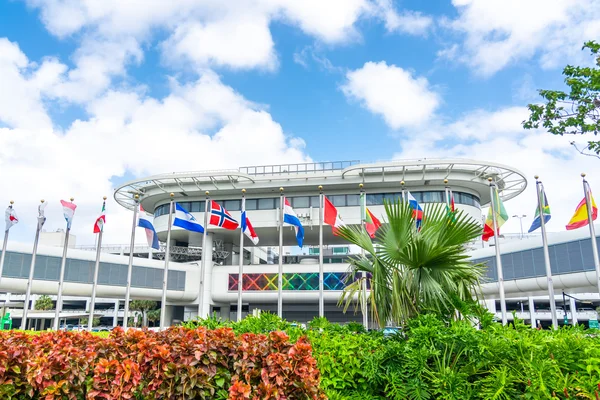 Terminal moderne de l'aéroport international de Miami avec drapeaux internationaux.