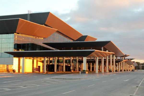 Il terminal moderno dell'Aeroporto Internazionale di São Paulo-Guarulhos con tetto arancione e nero al tramonto.