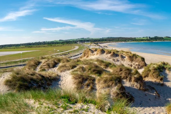 Vue aérienne de l'aéroport de Stavanger Sola avec dunes de sable et plage.