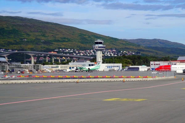 Terminal et tour de contrôle de l'aéroport de Tromsø entouré de montagnes.