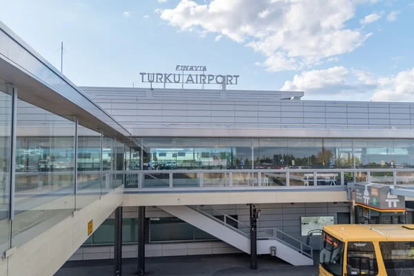Vue extérieure du terminal de l'aéroport de Turku avec signalisation et façade moderne.