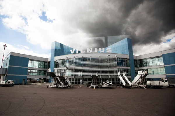 Terminal de l'aéroport international de Vilnius avec architecture bleue et verre.