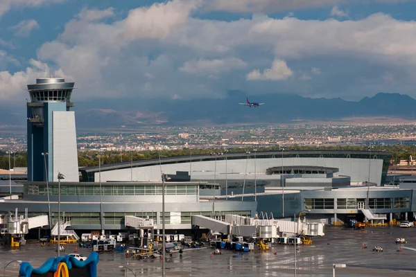 Vue aérienne de la tour de contrôle de l'aéroport Harry Reid avec bâtiments et montagnes.
