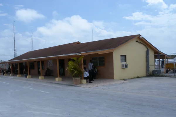 Terminal de l'aéroport international de North Eleuthera avec drapeau bleu et aile d'avion visible.