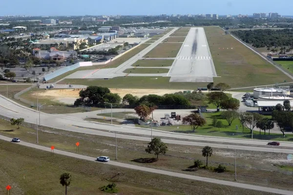 Vue aérienne de la piste de l'aéroport de Boca Raton avec infrastructure et paysage vert.