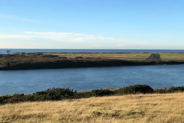 Vista panorámica del Aeropuerto de Barrow Walney Island rodeado de agua y vegetación.