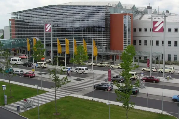Edificio terminal moderno con fachada metálica curva en el Aeropuerto de Dresde.