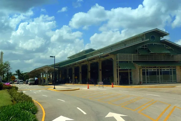 Terminal de l'aéroport international Casa de Campo avec palmiers tropicaux.