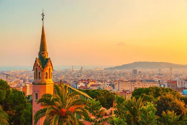 Sunset aerial view of Barcelona from Park Güell with Gaudí's mosaic tower and city skyline