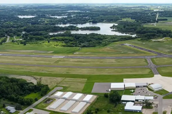 Vue aérienne d'un aéroport régional avec plusieurs pistes, des champs agricoles et des lacs dans la campagne des Pays-Bas