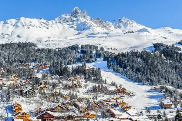 Estación de esquí alpino cubierta de nieve cerca de Chambéry con chalets de madera tradicionales y un espectacular pico montañoso
