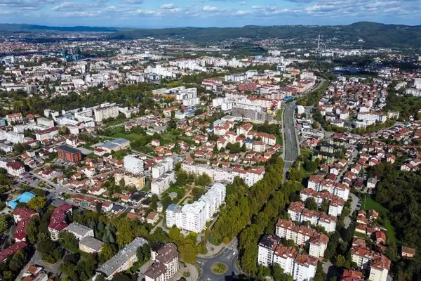 Aerial view of Brasov, Romania cityscape with residential neighborhoods, modern buildings, and surrounding Carpathian Mountains