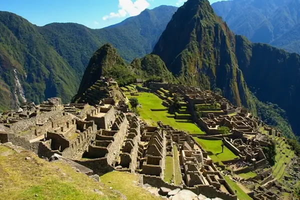Antiche rovine inca di Machu Picchu incastonate nelle montagne delle Ande del Perù, circondate da lussureggianti picchi verdi