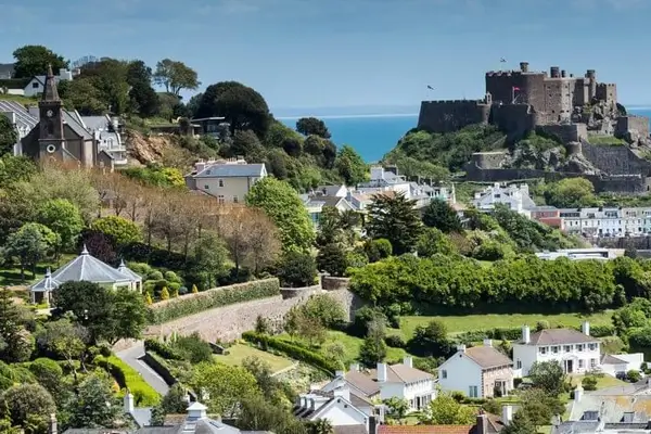 Vista aérea de un puerto en la isla de Jersey con el castillo de Mont Orgueil y el canal al fondo.