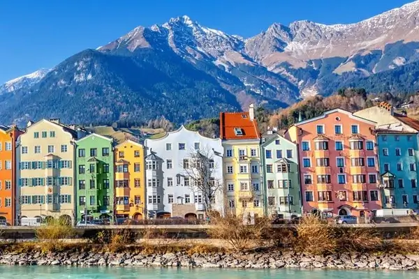 Casas de colores en Innsbruck con el río Inn en primer plano y las montañas al fondo