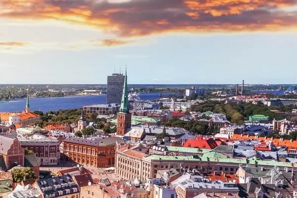 Vue aérienne de la vieille ville historique de Riga avec des bâtiments aux toits rouges, la flèche de la cathédrale et le fleuve Daugava au coucher du soleil, Lettonie