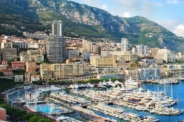 Vista a la luz del día soleado del Puerto de Hércules con yates, barcos y transbordadores en Mónaco