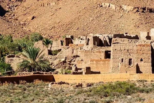 Antico forte kasbah con edifici in adobe costruiti contro una montagna desertica nella regione dell'Atlante del Marocco