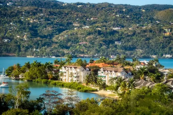 Station balnéaire en bord de lac nichée parmi la végétation tropicale avec des eaux turquoise et des collines boisées dans une destination tropicale