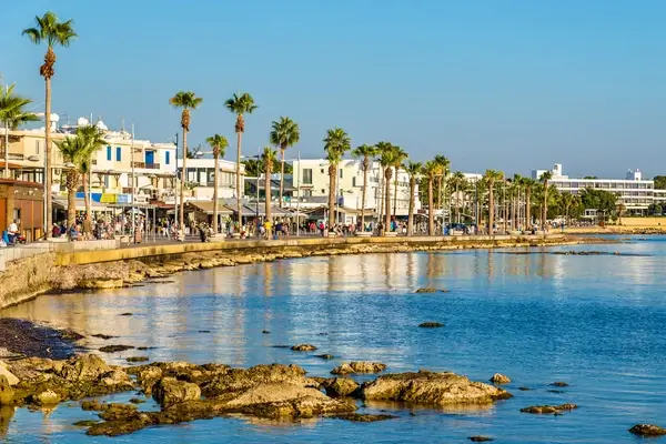 Paphos seafront with palm trees, Mediterranean blue waters, and traditional Cypriot architecture along the coastal promenade