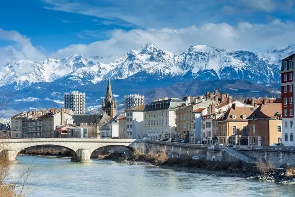 Paisaje urbano de Innsbruck con Alpes nevados, puente histórico sobre el río Inn y arquitectura medieval colorida