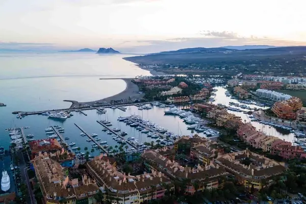 Aerial view of Lindau on Lake Constance with marina, waterfront buildings, and Alpine mountains at sunset