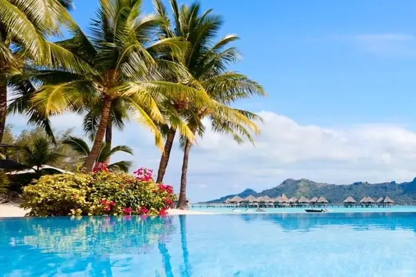 Vista di una spiaggia a Tahiti con le sue acque turchesi e il vulcano sullo sfondo