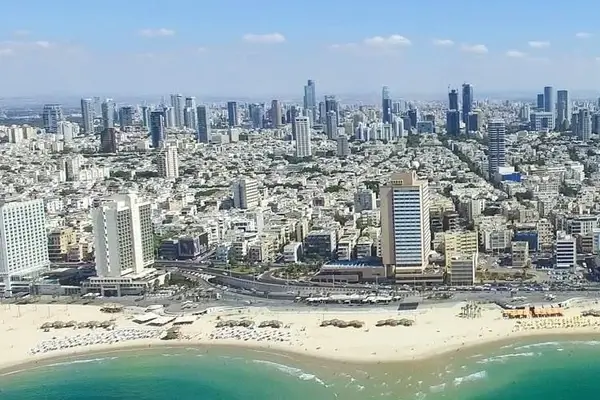 Foto von Tel Aviv in Israel mit, im Vordergrund, einem Strand, im Hintergrund, Wolkenkratzern