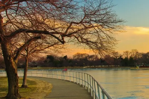 Vue d'une rivière avec un bâtiment blanc avec des colonnes en arrière-plan au coucher du soleil